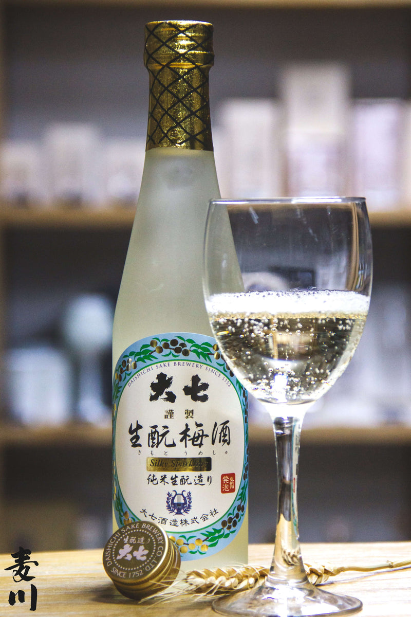 大七Silky Sparkling生酛梅酒，300ml白色瓶身搭配金色瓶蓋，旁放滿盛氣泡的玻璃酒杯，背景有模糊酒架。